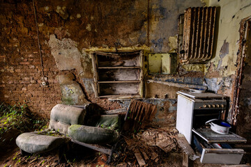 Verlassene Küche mit Möbeln in einem zerfallenen Gebäude