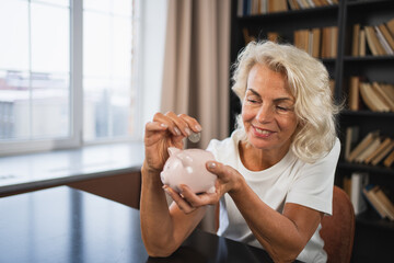 Saving money investment for future. Senior adult mature woman putting money coin in piggy bank. Old grandmother counting saving money planning retirement budget. Investment banking concept