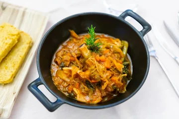 Fotobehang Cassoula with polenta. Meat on the bone with stewed vegetables © JackF