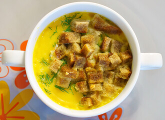 A traditional dish consisting of a bowl of stew topped with crispy croutons, served in elegant tableware. This staple food is a delicious and comforting choice for any meal
