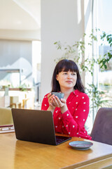 Thoughtful Businesswoman with Coffee in Bright Office