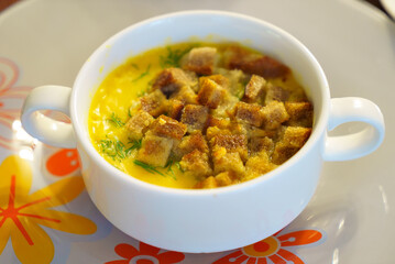 A traditional dish consisting of a bowl of stew topped with crispy croutons, served in elegant...
