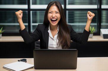 Une femme heureuse d'avoir r&eacute;ussie son travail sur son ordinateur.