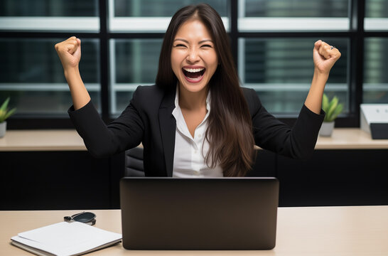 Une femme heureuse d'avoir r&eacute;ussie son travail sur son ordinateur.