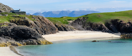 Plage de sable fin de Clachtoll beach avec mer au premier plan et montagnes à l'horizon en Ecosse