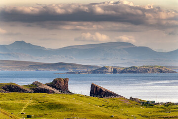 Vue de deux rochers face &agrave; face sur la mer et les montagnes &agrave; Clachtoll beach en Ecosse