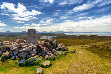 Vue panoramique des lochs, des montagnes et de mer avec au premier plan un empilement de pierres de...