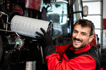 Experienced mechanic or serviceman changing air filter on tractor agricultural machine. Service and...