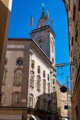 Salzburg, Austria, August 15, 2022. Fascinating shot of the town hall clock tower. The red and white flags stand out.
