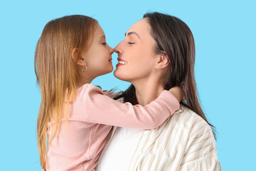 Young woman with her cute little daughter touching noses on blue background, closeup. Mother's Day...