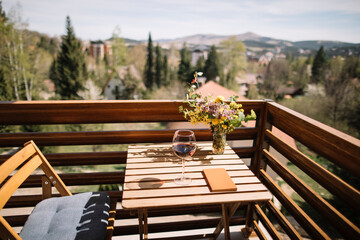 Small balcony idyll, wineglass and book on balcony table.