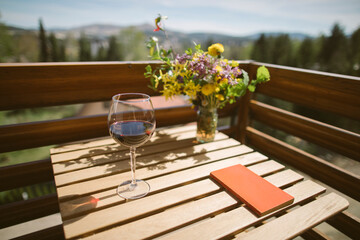 Small balcony idyll, wineglass and book on balcony table