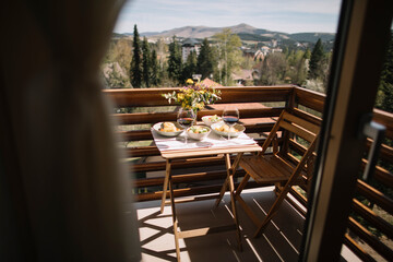 Small balcony idyll with lunch and wine viewed from inside