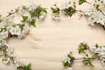 Frame made of beautiful blossoming branches on wooden background