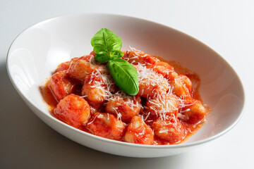 White bowl with tomato potato dumpling