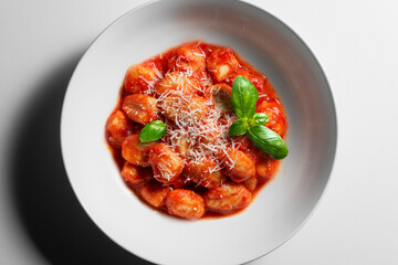 White bowl with tomato potato dumpling