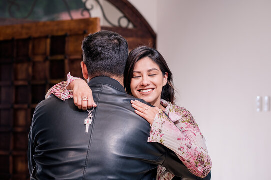 The happy wife hugs her husband when he gives her the keys to their new home.