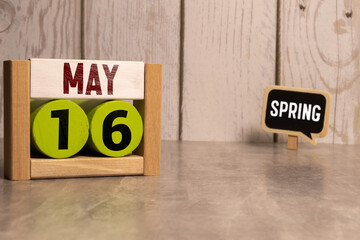 Vintage photo, May 16th. Date of 16 May on wooden cube calendar, copy space for text on board.