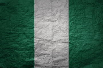 big national flag of nigeria on a grunge old paper texture background