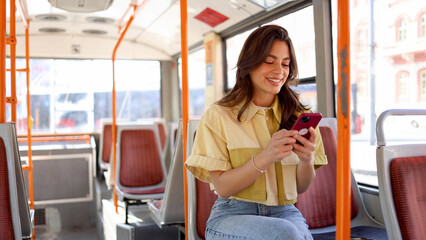 Young female Mexican using smartphone in the bus