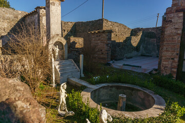 Garden inside ancient Casa di Marco Lucrezio sulla via Stabiana with marble sculptures in the ruins of Pompeii, Campania, Italy