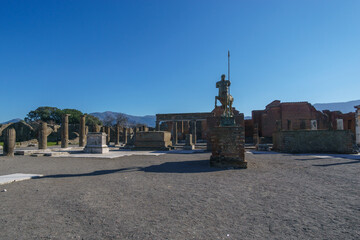 View of a bronze statue at the ruins of the Forum on a sunny day with clear blue sky, Pompeii, Campania, Italy