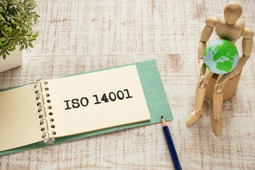 There is notebook with the word ISO 14001. It is as an eye-catching image.
