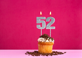 Birthday cupcake with candle number 52 - Birthday card on pink background