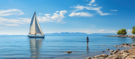 Obraz premium Sailboat Sailing in the middle of the sea isolated bluish clear sky