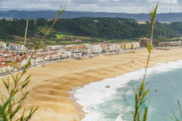 Bird's-eye view captures the sprawling mosaic of Nazare's urban grid contrasted with natural surroundings. - 786721100