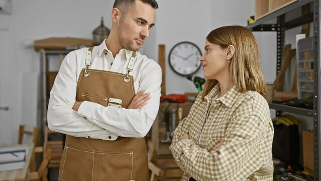 A man and woman in aprons stand confidently in a woodworking workshop, implying a team of skilled carpenters.