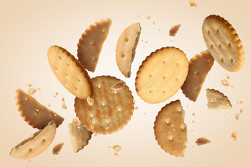 Tasty dry crackers falling on beige background