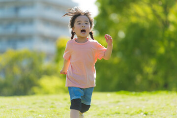 芝生の公園で走って遊ぶ子ども - obrazy, fototapety, plakaty
