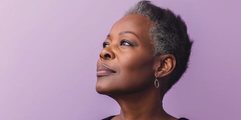Relaxed middle-aged Black woman with closed eyes and natural curly hair, set against a lilac-colored wall.
