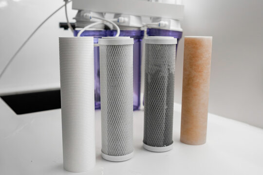 Four filters for the purification system of water on the table in the kitchen
