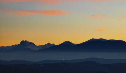 Le montagne in controluce in un luminoso tramonto arancione