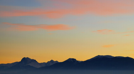 Le montagne in controluce in un luminoso tramonto arancione