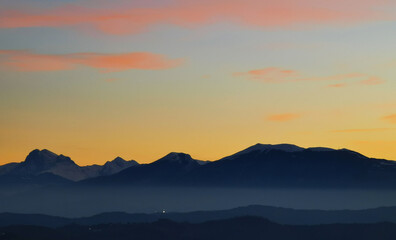 Le montagne in controluce in un luminoso tramonto arancione