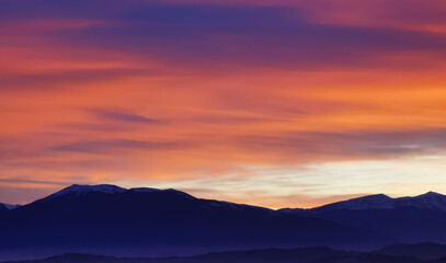 Nuvole rosse al tramonto sulla cime delle montagne