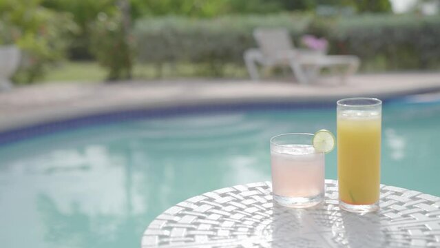 two healthy natural organic juice cocktail with swimming pool on background 