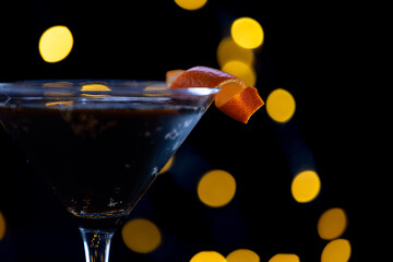 A martini glass with a slice of orange on top. Concept of sophistication and elegance