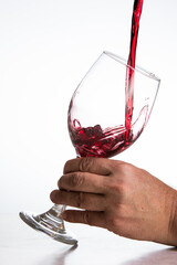 Action shot pouring red wine into a glass over a white background - 786753385