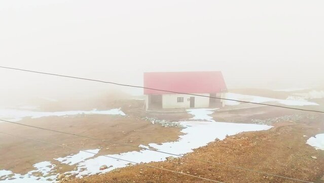 a small house in the middle of a snowy mountain