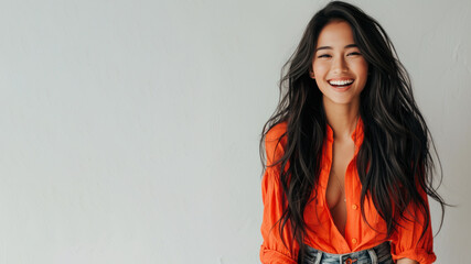 Malay woman wear orange shirt smiling laugh out loud isolated on grey