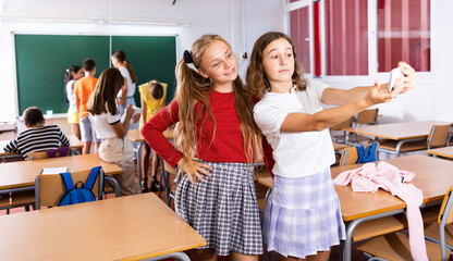 Two positive schoolgirls are photographed during a break in the school class