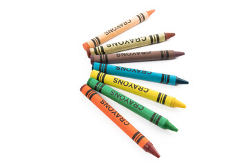 overhead view of a fan of colorful crayons  with a generic label on a white table