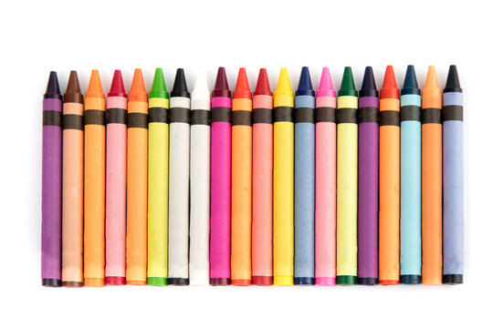overhead view of a row of colorful wax crayons on a white table