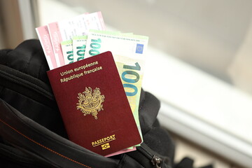 French passport and euro money bills with airline tickets on backpack close up