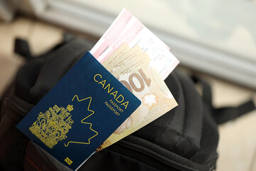 Canadian passport and dollar money bills with airline tickets on backpack close up - obrazy, fototapety, plakaty
