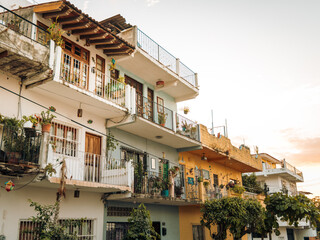 Typical Mexican style apartment flats with balconies with colorful paint and decorations. Low angle.